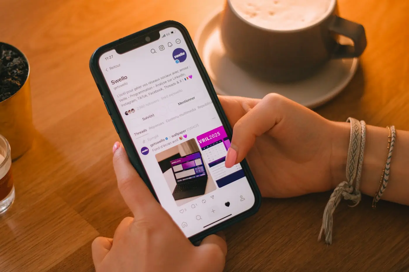 Hands scrolling a social media feed on a smartphone