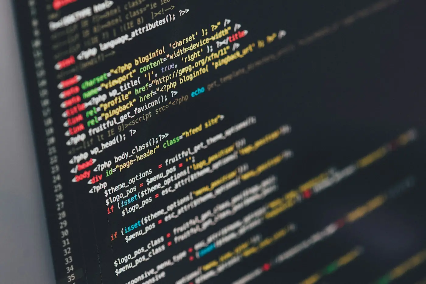 A monitor showing lines of code in a dark editor